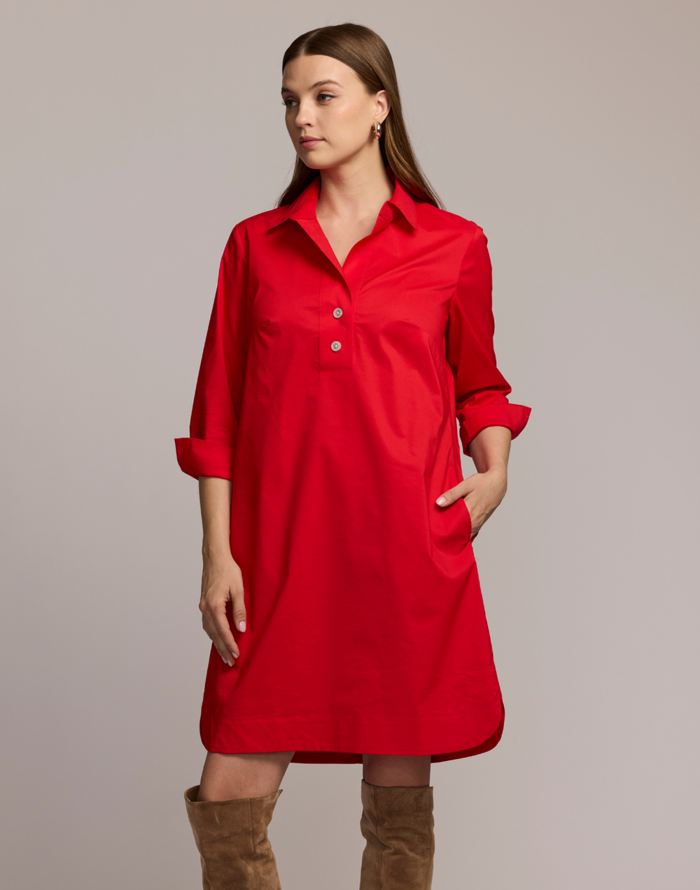 Woman wearing a red dress with 3/4 sleeves against a plain background