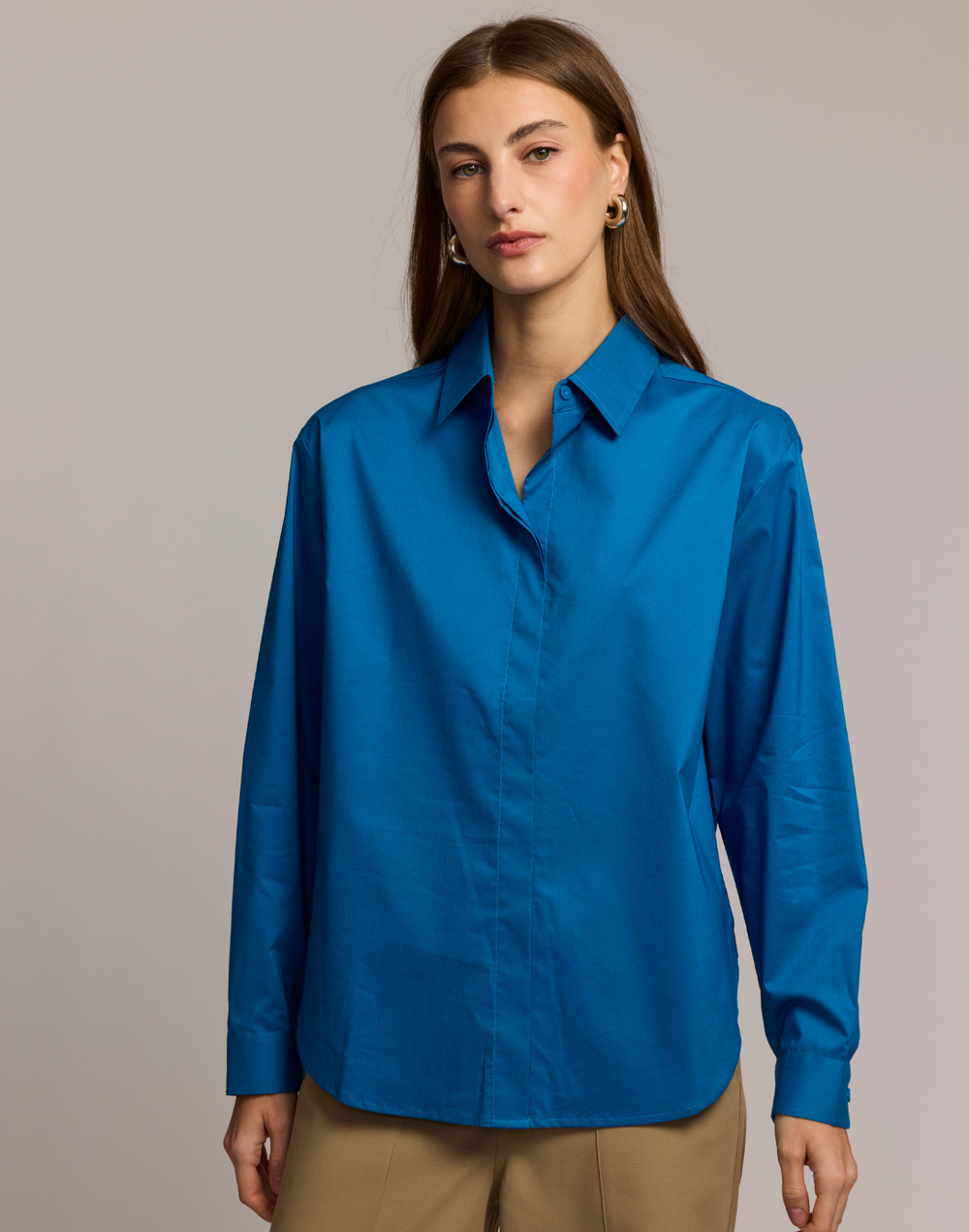 Woman wearing a blue shirt against a neutral background