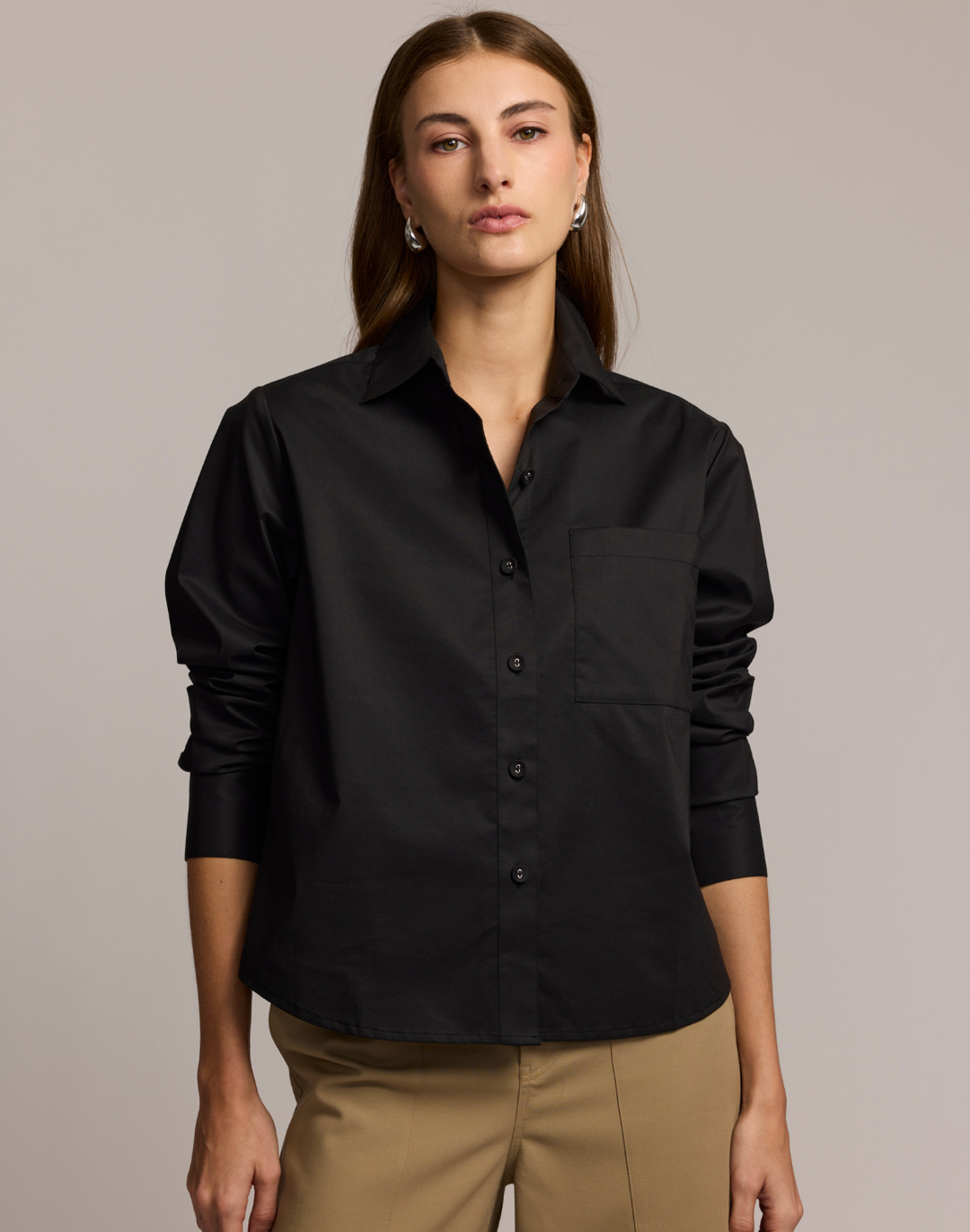 Woman wearing a black shirt against a plain background