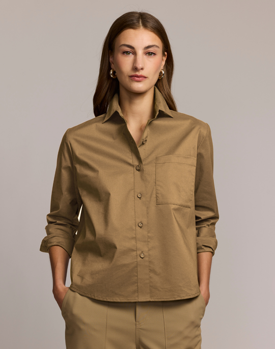 Woman wearing a brown shirt with a plain background