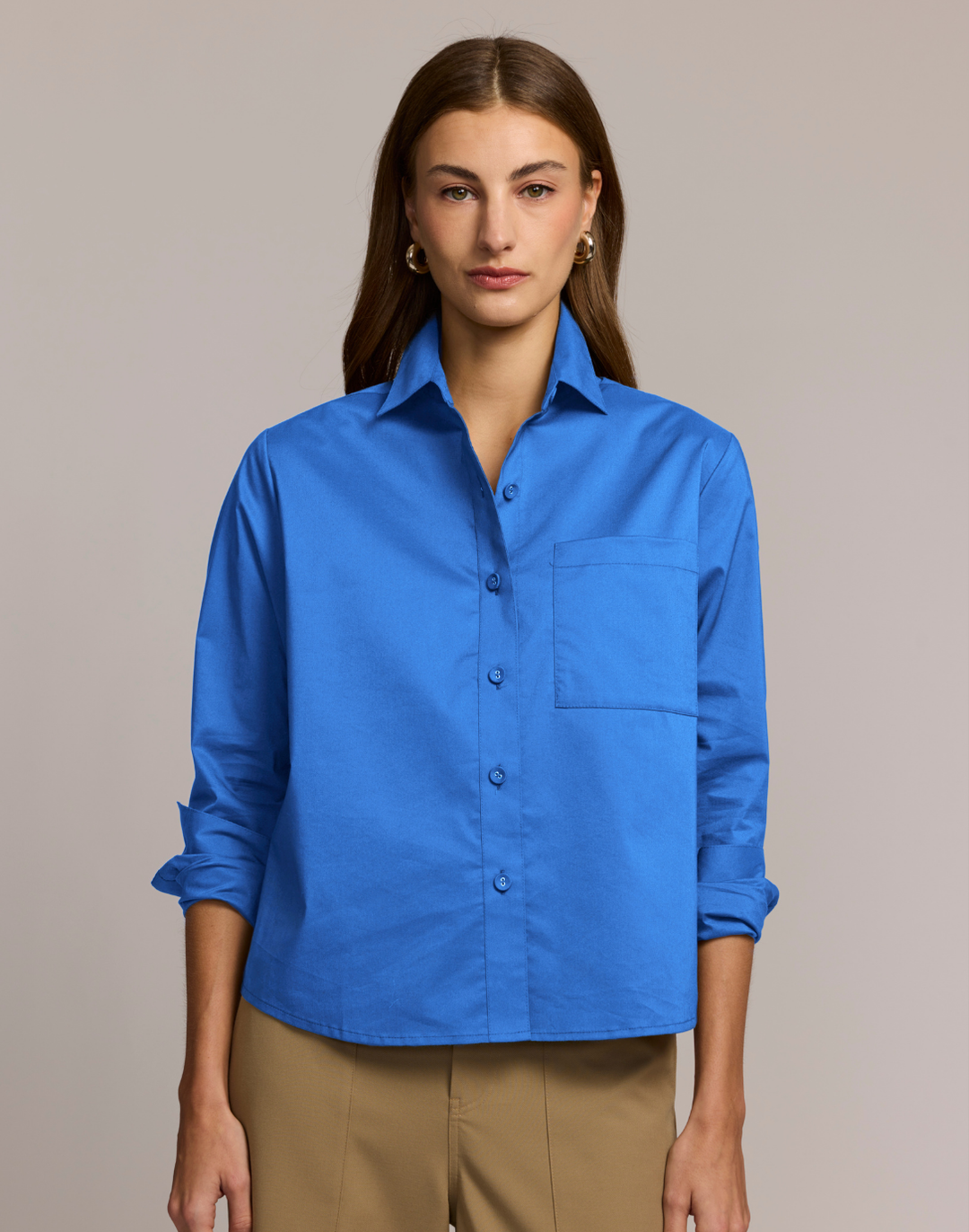 Woman wearing a blue shirt against a beige background