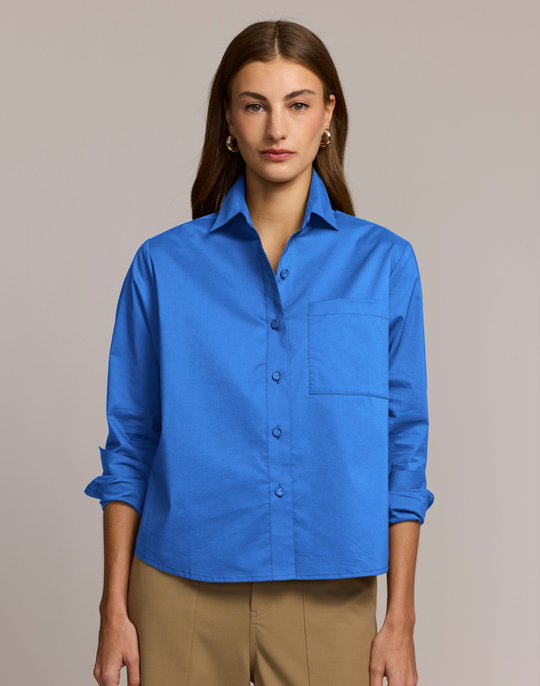 Woman wearing a blue shirt against a beige background