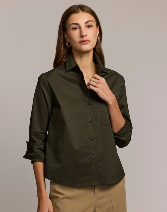 Woman wearing a dark green shirt against a plain background