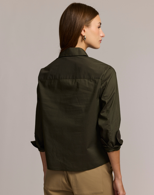 Woman wearing an olive green shirt against a plain background