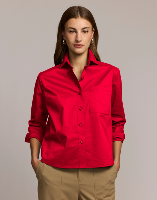 Woman wearing a red shirt against a plain background