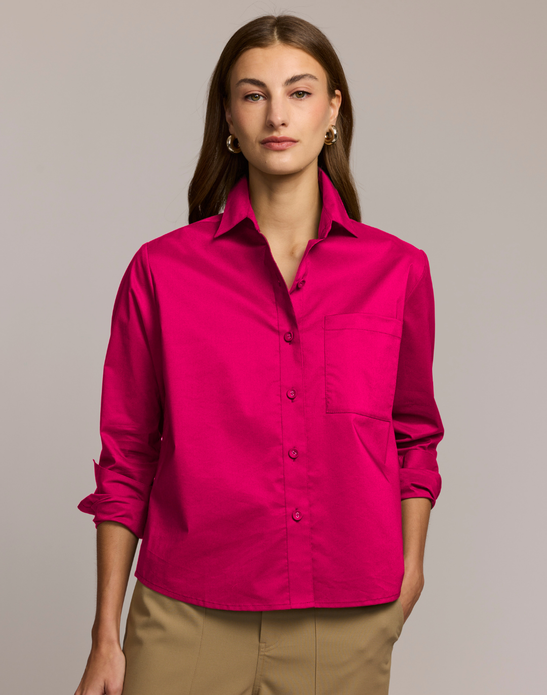 Woman wearing a bright pink shirt against a neutral background