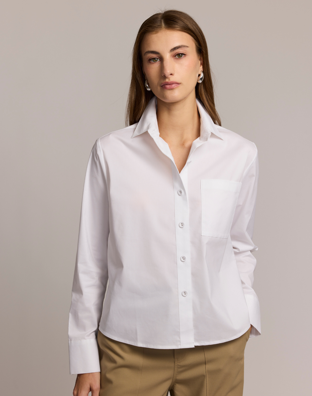 Woman wearing a white shirt against a plain background