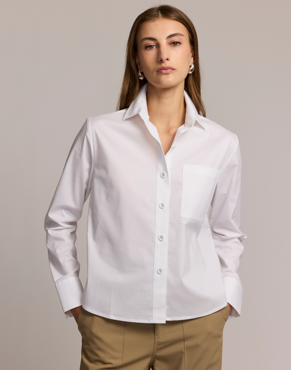 Woman wearing a white shirt against a plain background