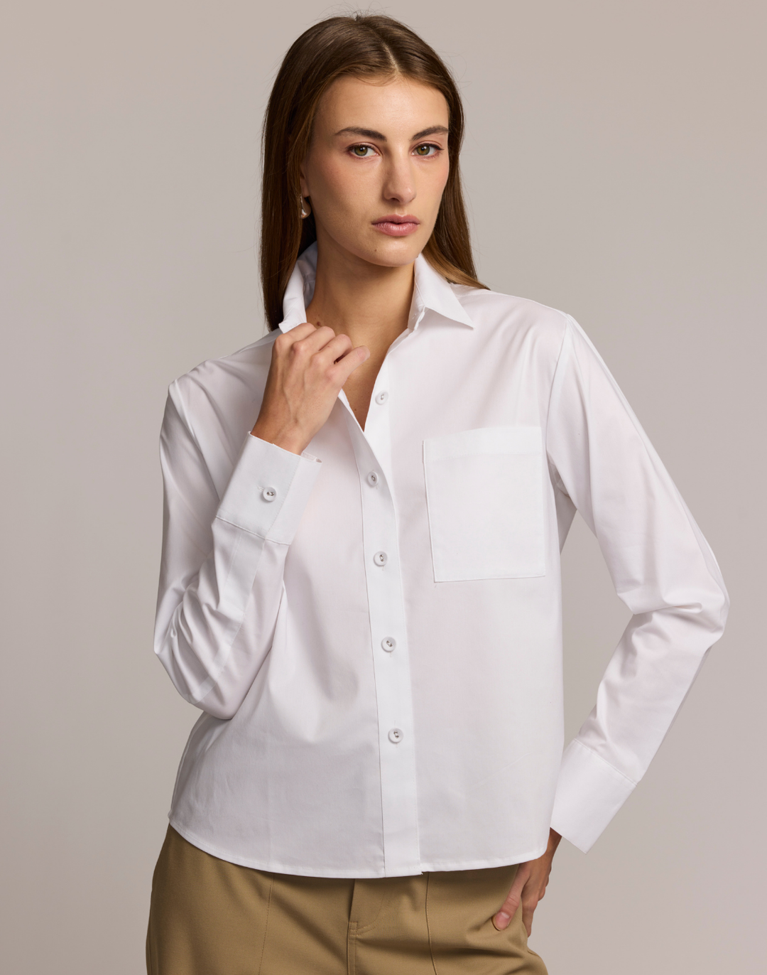 Woman wearing a white shirt against a plain background