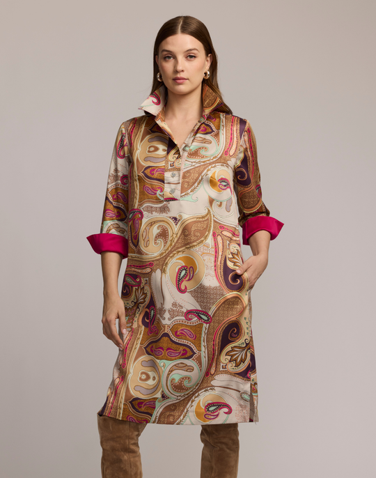 Woman wearing a scarf patterned dress with a neutral background