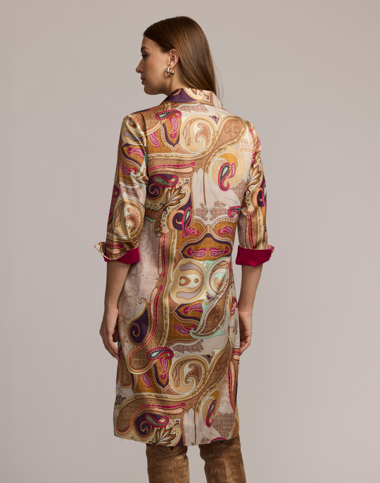 Woman wearing a scarf patterned dress with a neutral background