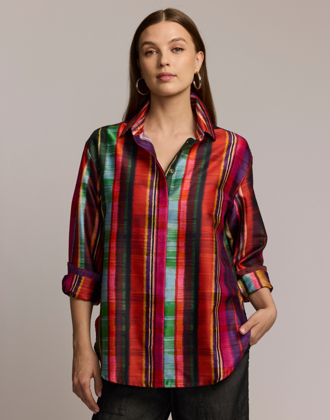 Woman wearing a colorful striped shirt against a neutral background