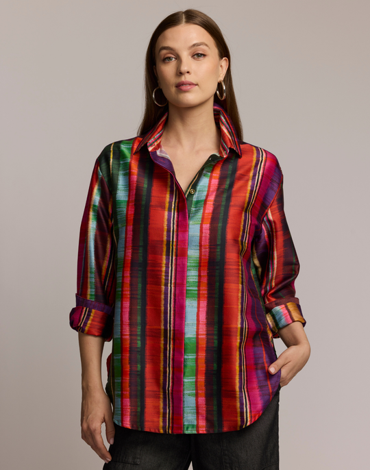 Woman wearing a colorful striped shirt against a neutral background