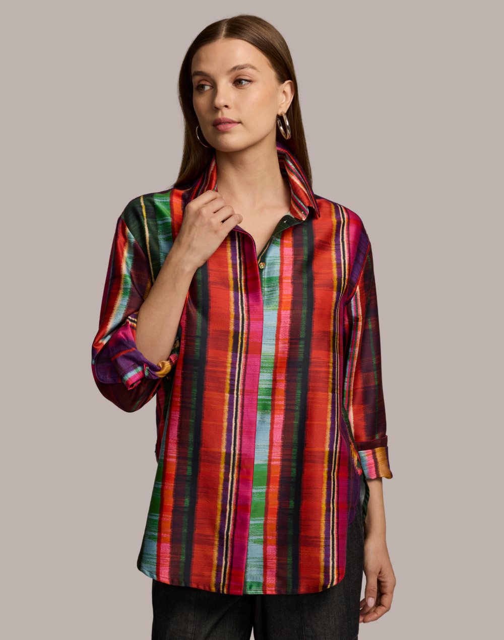  Woman wearing a colorful striped shirt against a neutral background