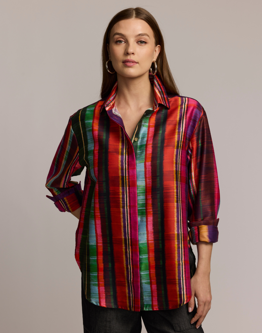 Woman wearing a colorful striped shirt against a neutral background