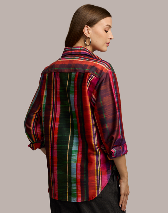 Woman wearing a colorful striped shirt against a neutral background